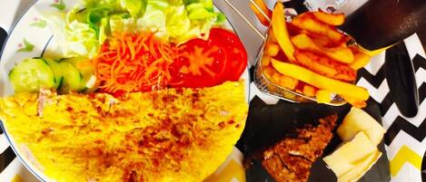 Bandeja con un wrap, ensalada, papas fritas y una bebida.