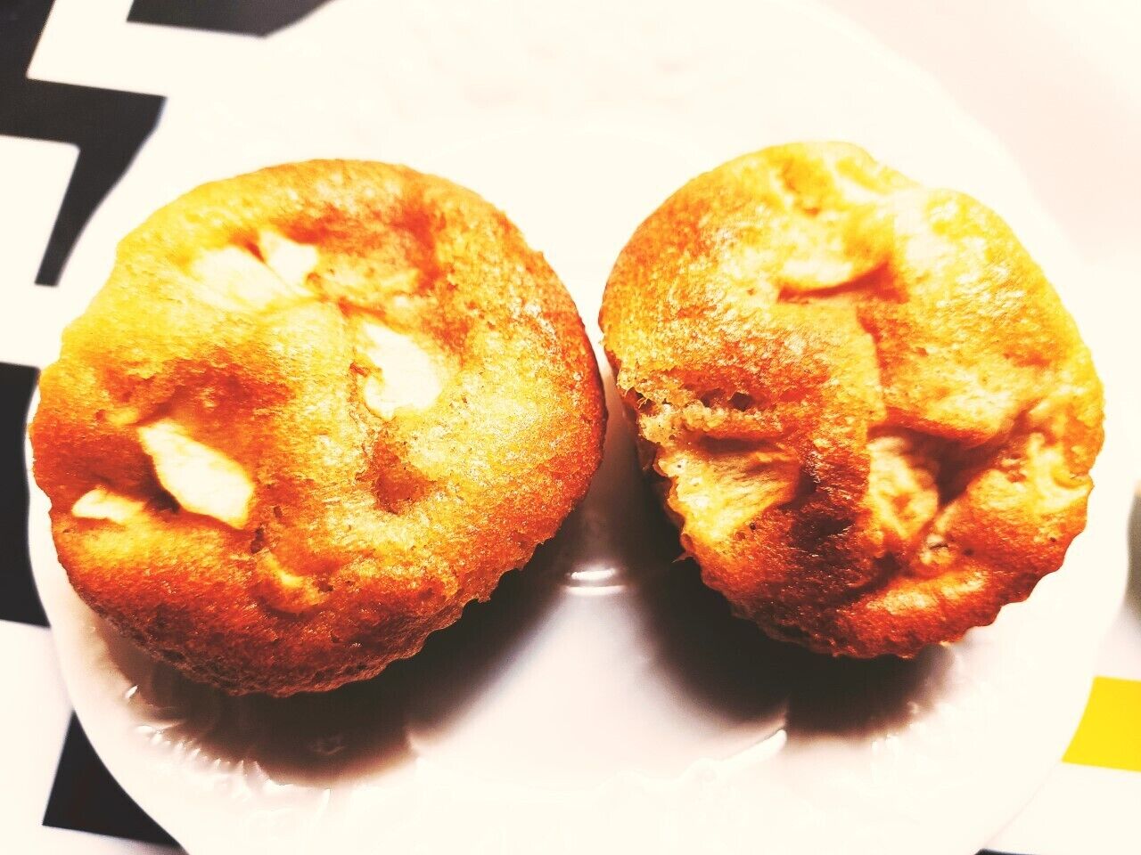 Two muffins on a white plate.