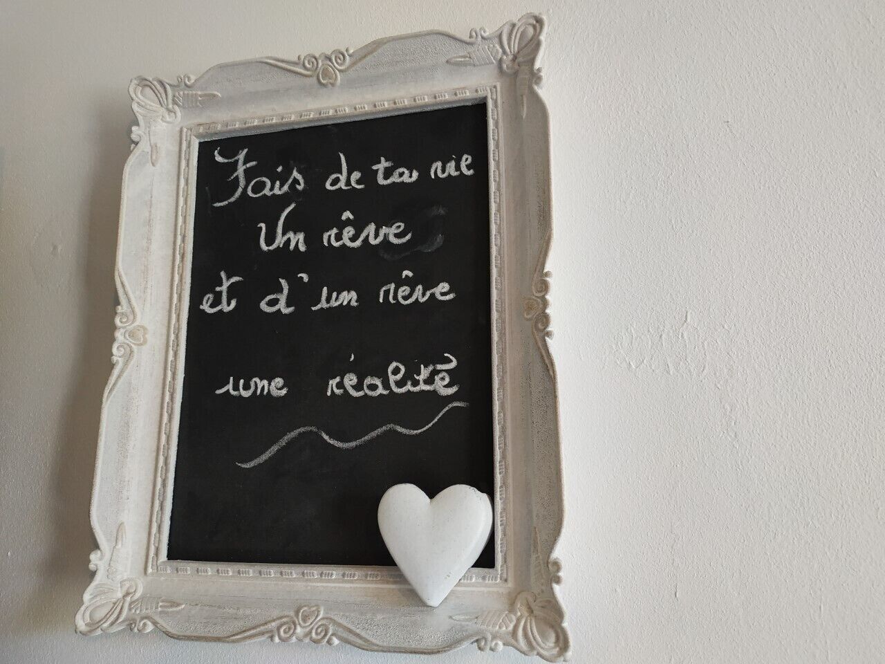 A chalkboard with a French message and a heart-shaped decoration.