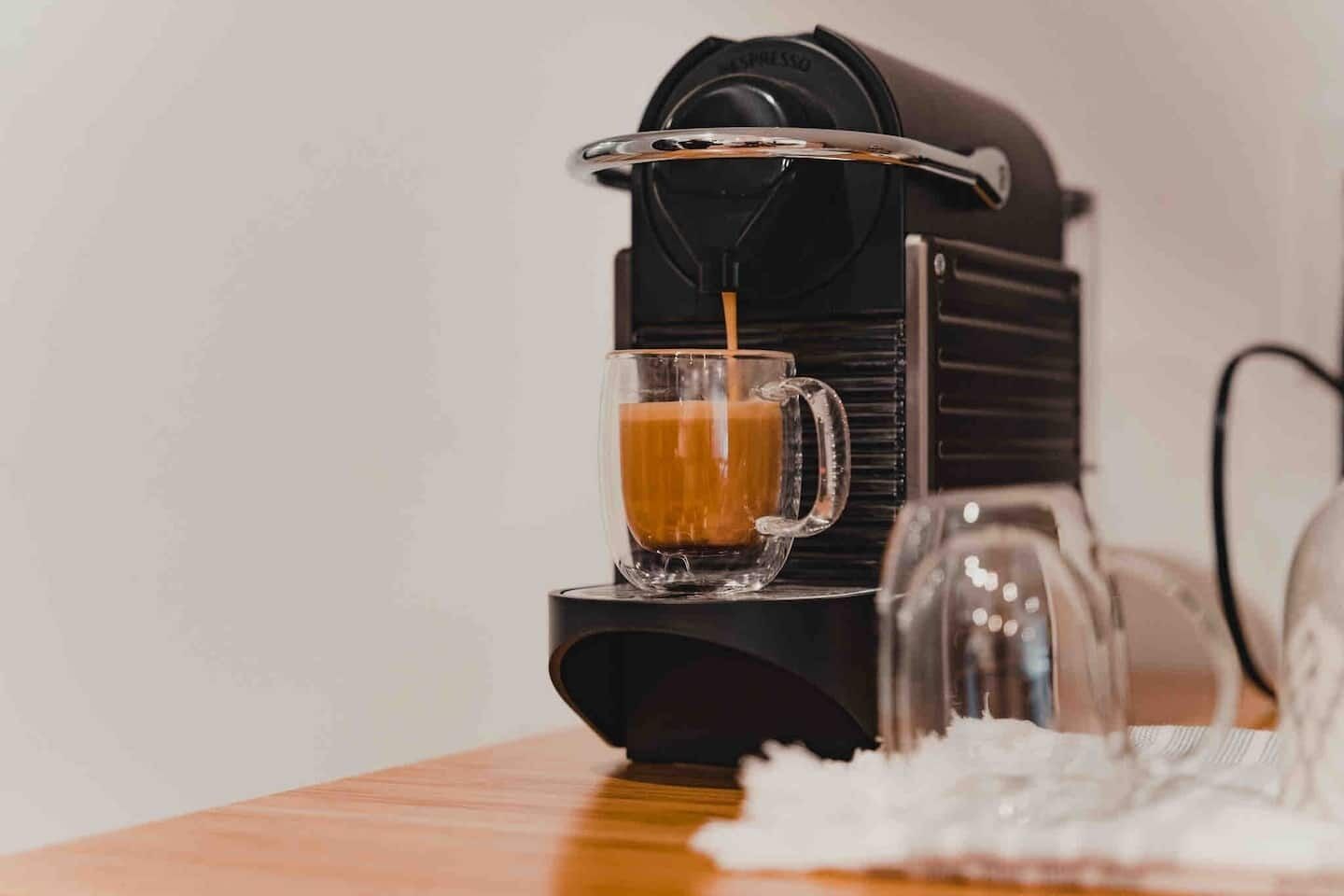 A coffee machine dispensing coffee into a glass mug.