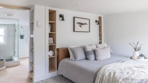 A modern bedroom with a built-in wardrobe, a bed with grey bedding, and a framed whale picture on the wall. - The QV Stage, Lux Couples Retreat W/ Outdoor Sauna (St. John's)