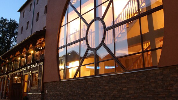 Un edificio con un amplio ventanal circular y fachada de piedra.