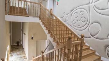 Una escalera con barandillas de madera y un revestimiento mural estampado.