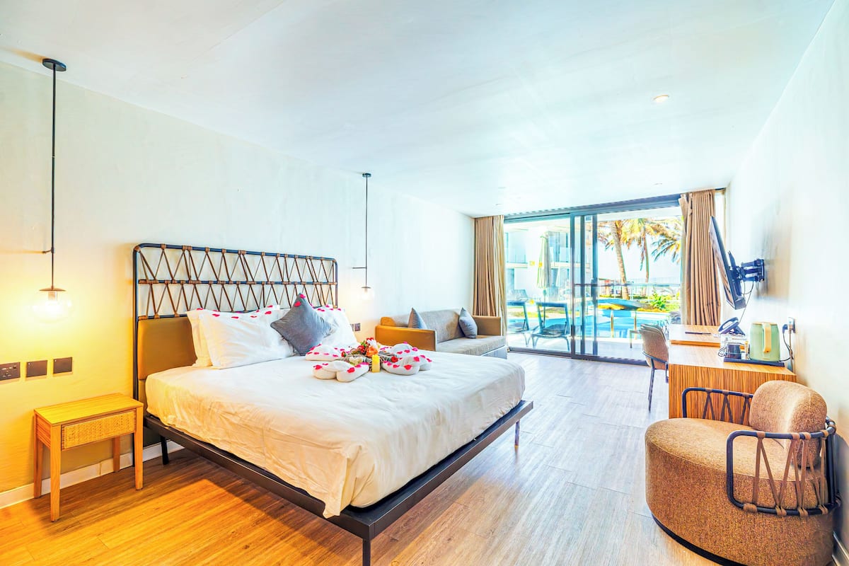 Una habitación de hotel con una cama, un escritorio, una silla y vistas al exterior.