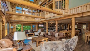 A spacious wooden interior with a living area, dining space, and kitchen. - PinnacleView: POOL, Breathtaking Views, Movie Room, Games, Hot Tub, Wifi (Sevierville)