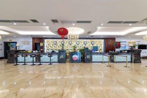 A hotel reception area with a marble floor, a reception desk, and a red hanging ornament. - Jingxi Global Hotel (Jingxi)