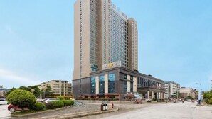 A tall hotel with a modern facade, multiple floors, and a prominent entrance. - Jingxi Global Hotel (Jingxi)