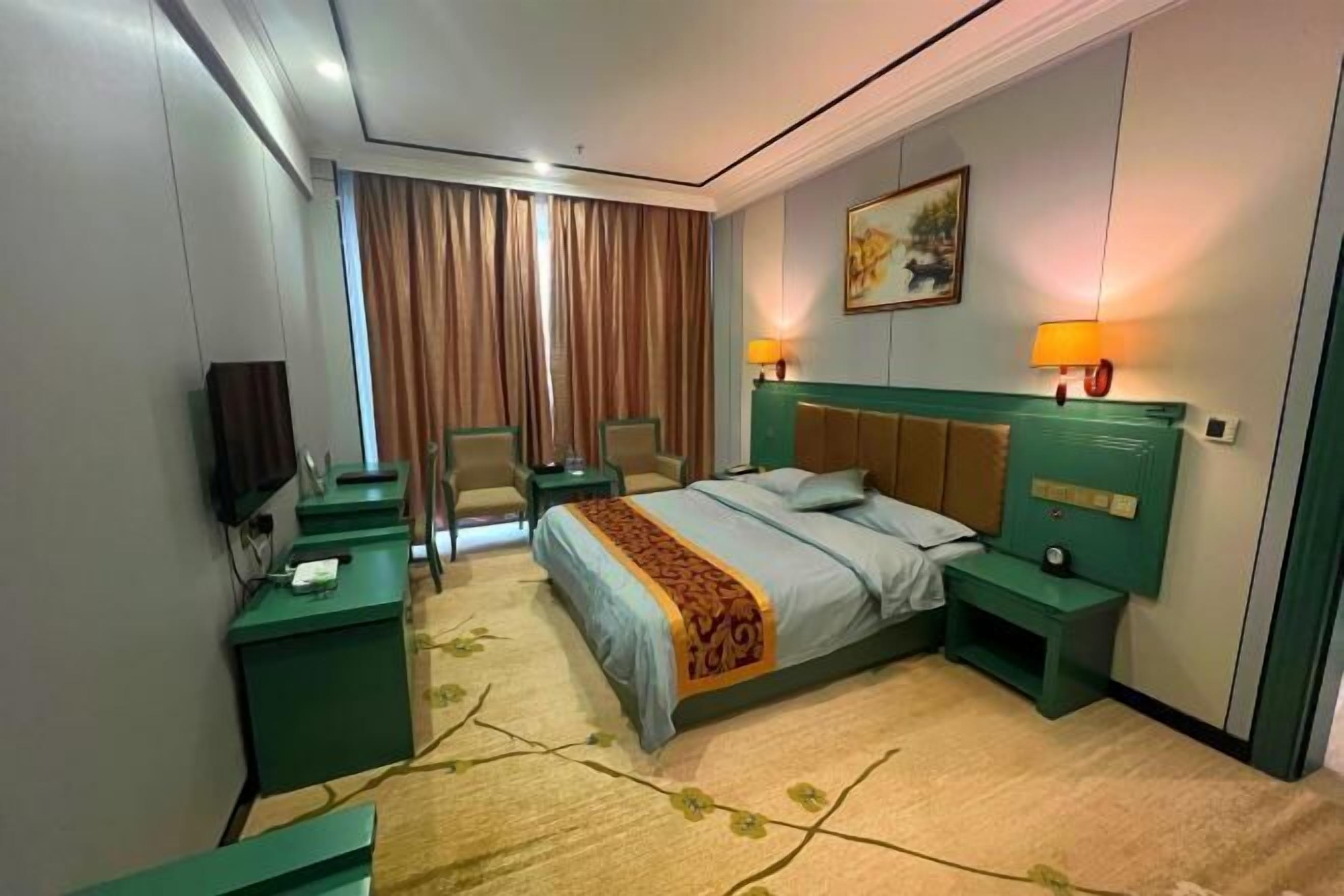 A hotel room with a bed, two bedside tables, a desk, a chair, a television, and a window with curtains.