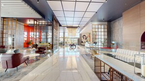 A spacious lobby with a high ceiling, modern furniture, and a central seating area. - Radisson Red Chandigarh Mohali (Mohali)