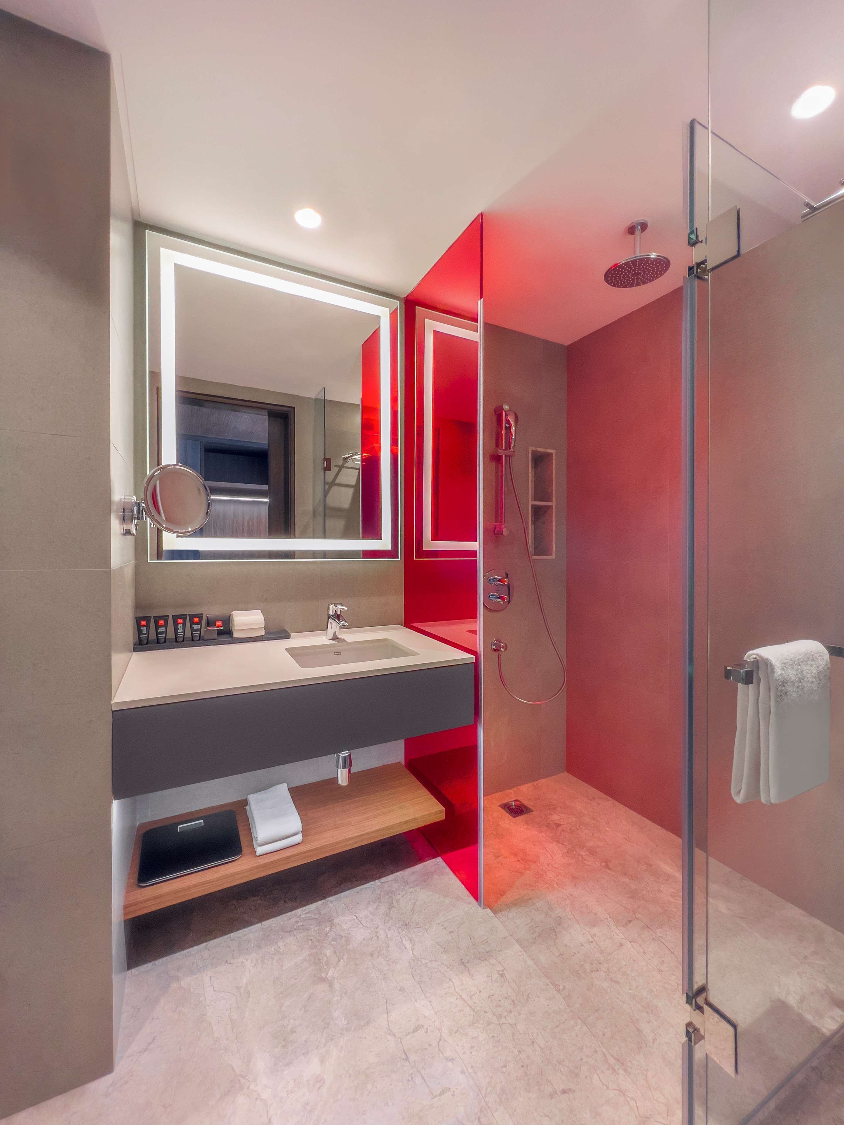 A modern bathroom with a glass shower enclosure, a vanity with a mirror, and a towel rack.