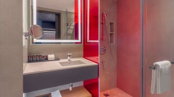 A modern bathroom with a glass shower enclosure, a vanity with a mirror, and a towel rack.