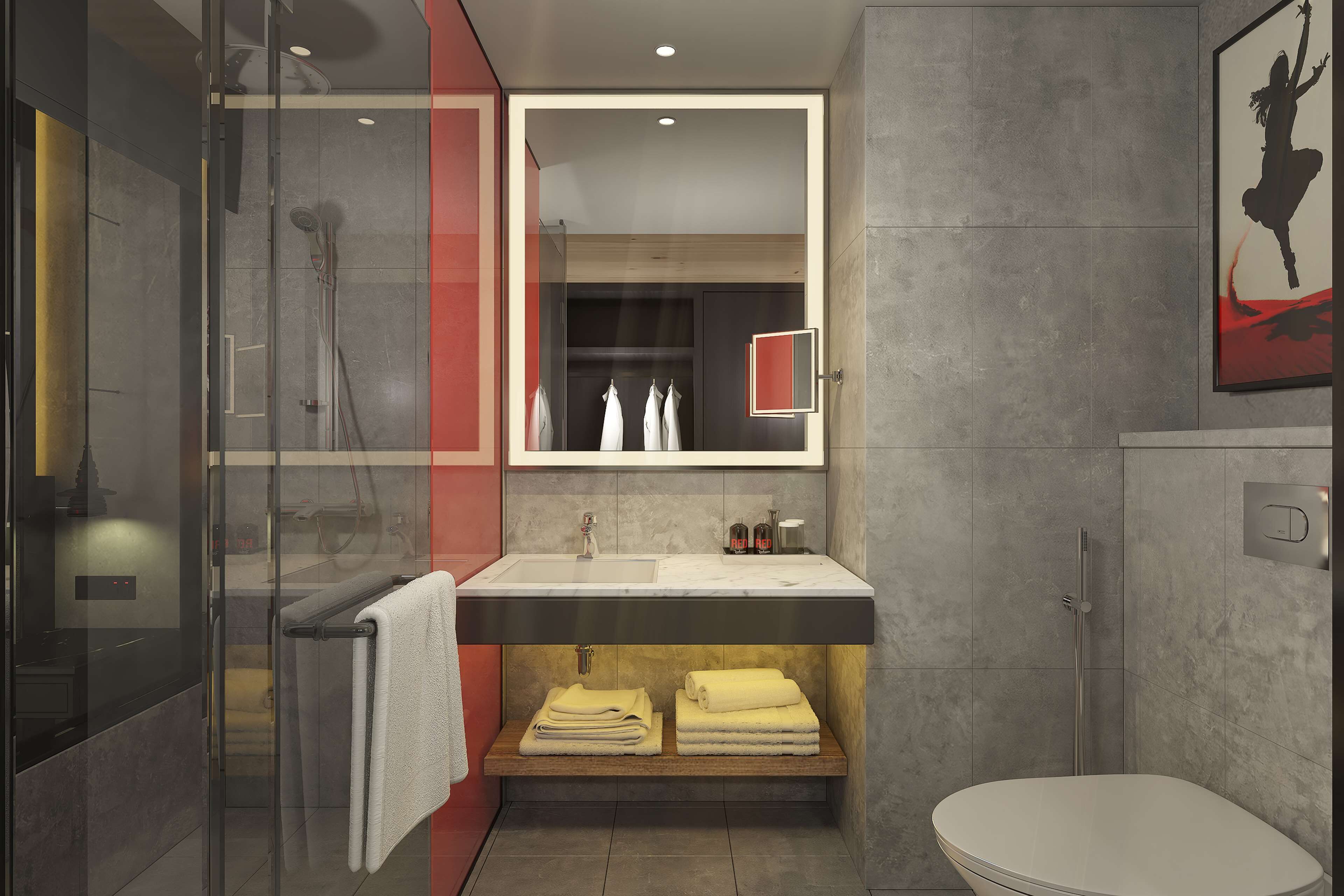 A modern bathroom with a glass shower enclosure, a vanity with a mirror, and a toilet.