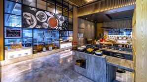 A modern kitchen with marble countertops, a variety of food items displayed, and a menu board listing pasta options. - Radisson Red Chandigarh Mohali (Mohali)
