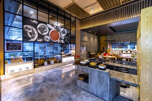 Una cocina moderna con encimeras de mármol, varios alimentos a la vista y un panel con opciones de pasta.