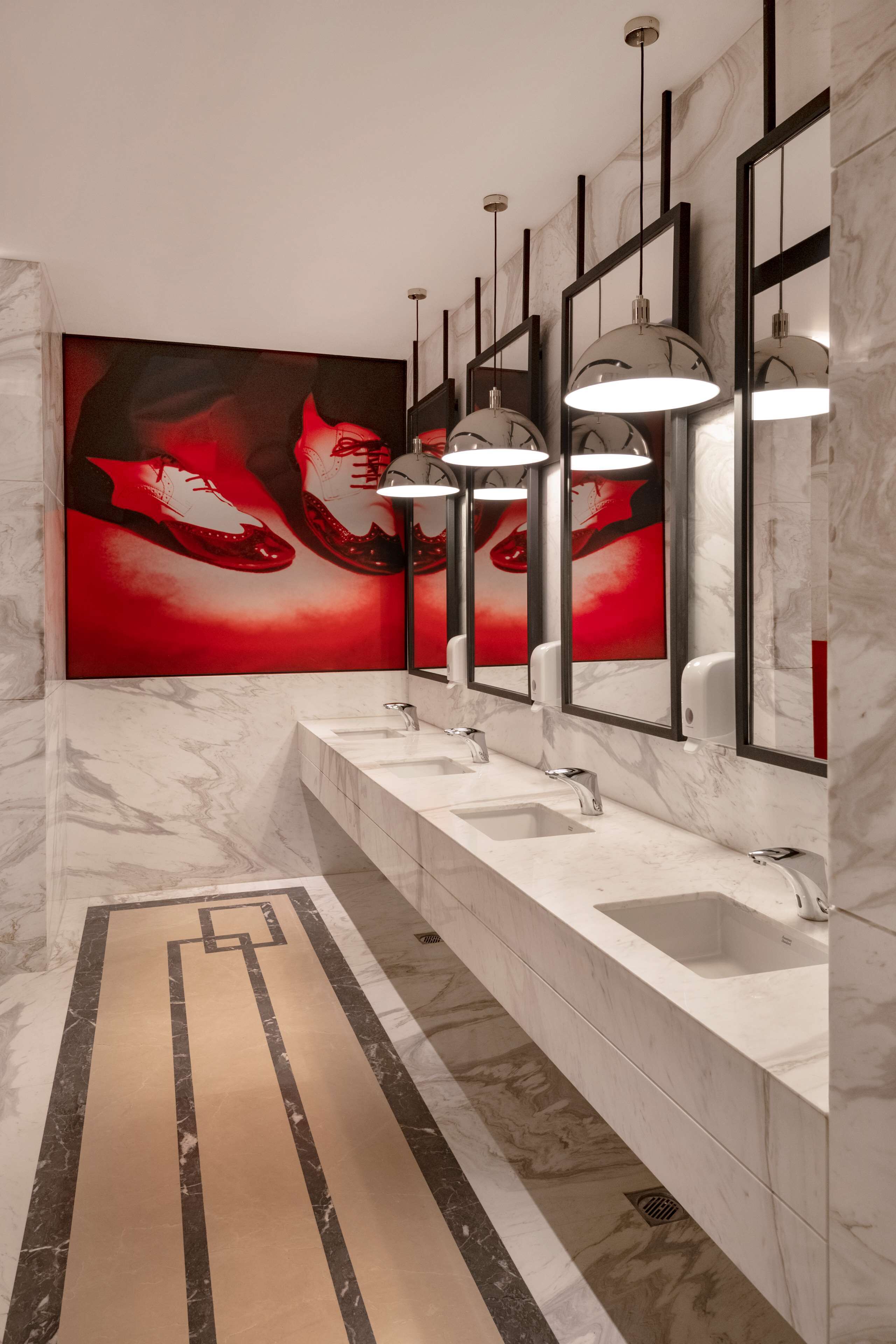 A modern bathroom with a long vanity, three sinks, and a large mirror.