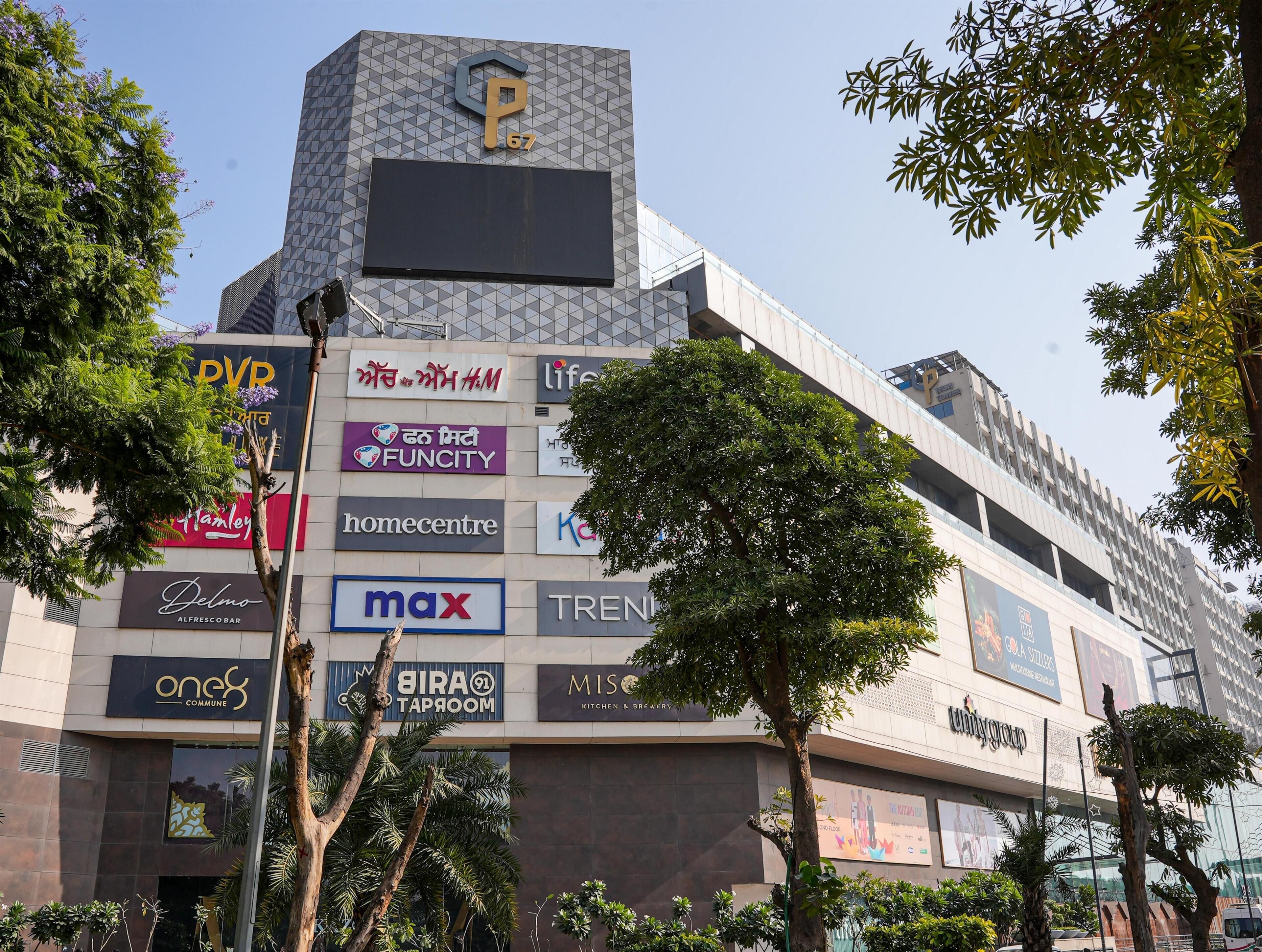 A modern building with multiple commercial signs, including 'FUNCITY', 'max', and 'TREND'.