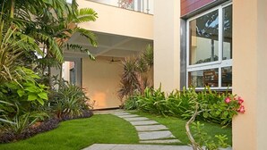 A pathway leading to a building entrance with a small garden area. - Maroma Suites (Chennai)