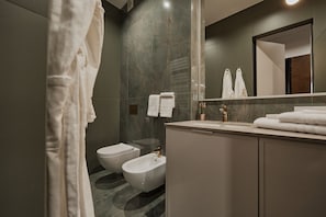 Un baño moderno con un bidé, un inodoro y un lavamanos.