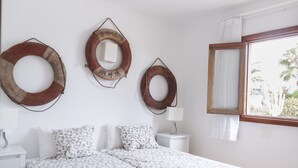 A hotel room with a bed, two bedside tables, and three wall-mounted circular mirrors.
