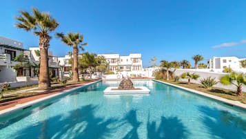 Een buitenzwembad, ligstoelen bij het zwembad