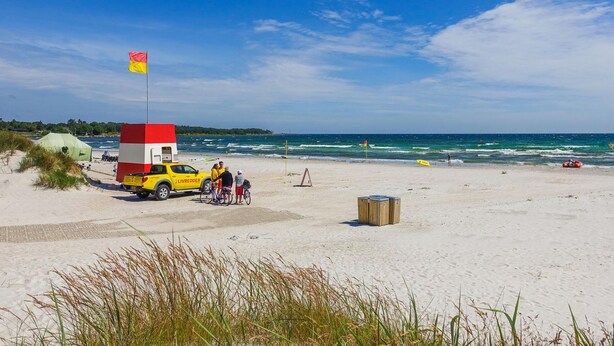A beach with a lifeguard station, a yellow truck, and a clear blue sky. - 1 bedroom stunning home in Nexø (Nexø)