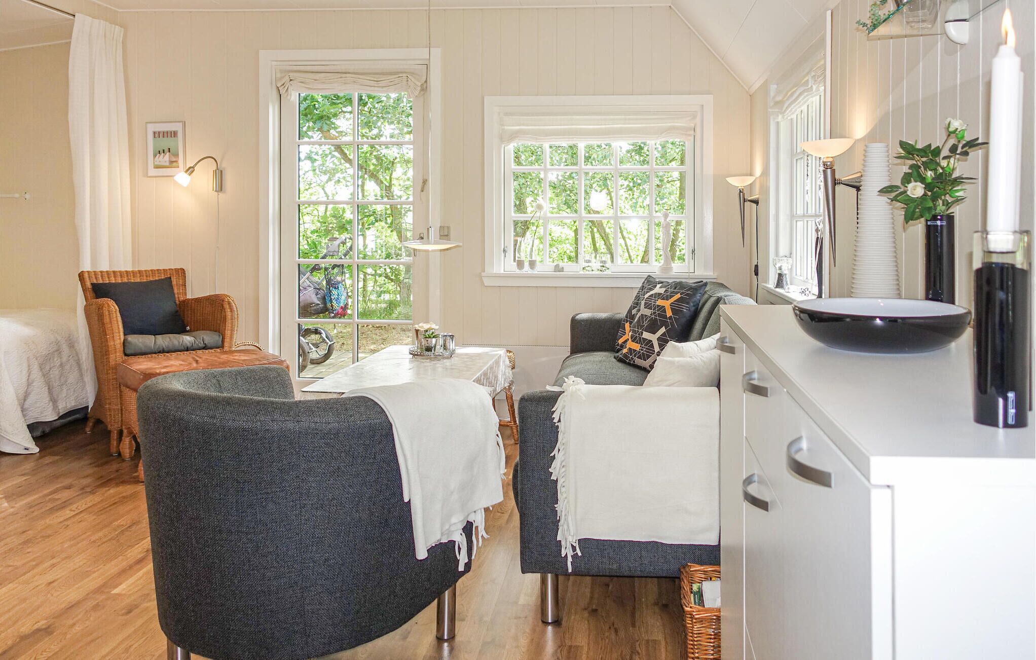 A cozy room with a dining table, two chairs, a sofa, and a bed.