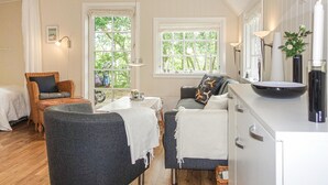 A cozy room with a dining table, two chairs, a sofa, and a bed. - 1 bedroom stunning home in Nexø (Nexø)