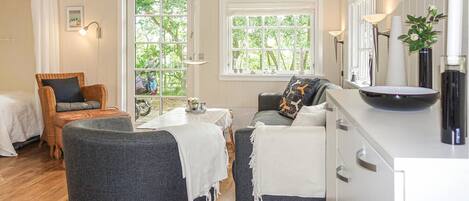 Une pièce confortable avec une table à manger, deux chaises, un canapé et un lit.