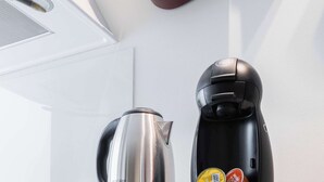 A black kitchen appliance with a kettle and coffee maker on top. - Charmant Studio Paris 15e Proche Tour Eiffel (Paris)