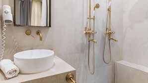 A modern bathroom with a round white sink, gold fixtures, a large mirror, and a shower with gold fixtures. - Charmant Studio Paris 15e Proche Tour Eiffel (Paris)