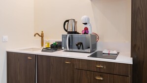 Eine moderne Küche mit eingebautem Backofen, Mikrowelle und Kaffeemaschine.