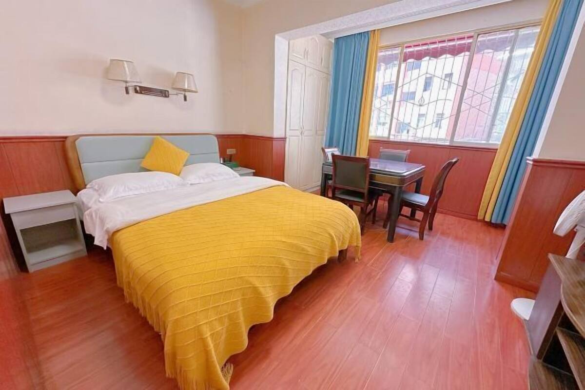 Une chambre d’hôtel avec un lit, un bureau et une chaise.