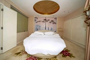 Un dormitorio con cama, armario, espejo y techo con diseño circular.