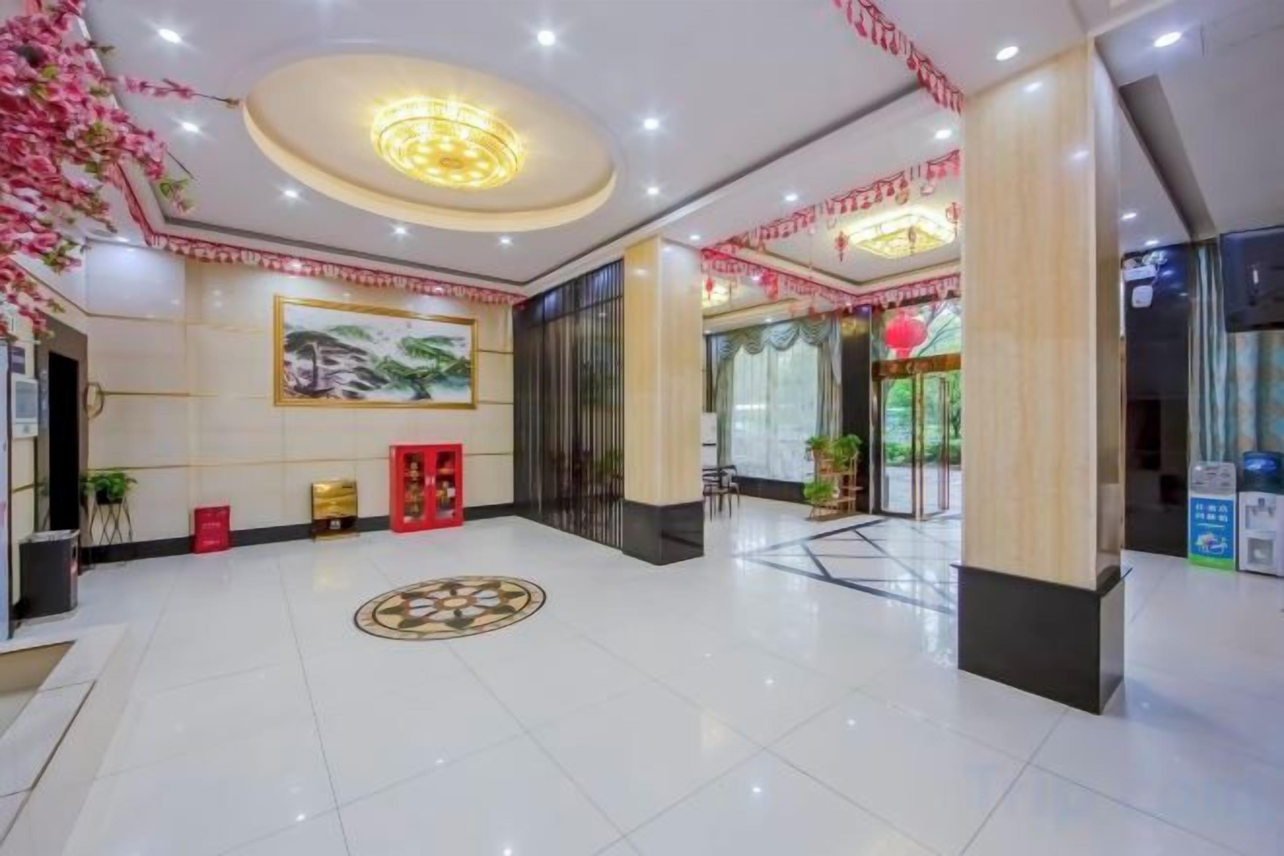 A hotel lobby with a reception desk, a large painting, and a circular decorative floor pattern.