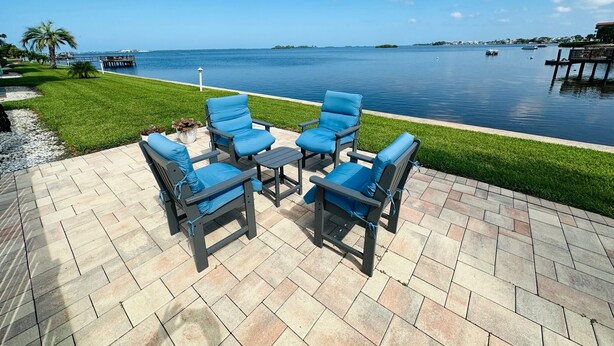 Un patio con mobiliario exterior con vista a un cuerpo de agua.
