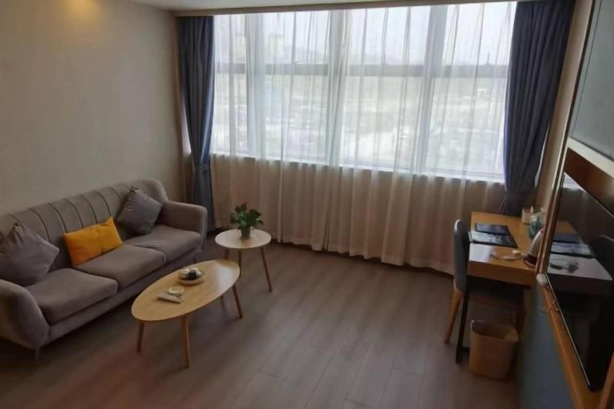 Una sala de estar con sofá, mesa de centro y escritorio con silla.