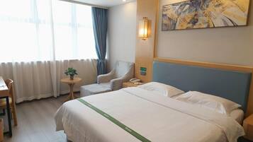 A hotel room with a large bed, a chair, a small table with a plant, a painting on the wall, and a window with curtains.