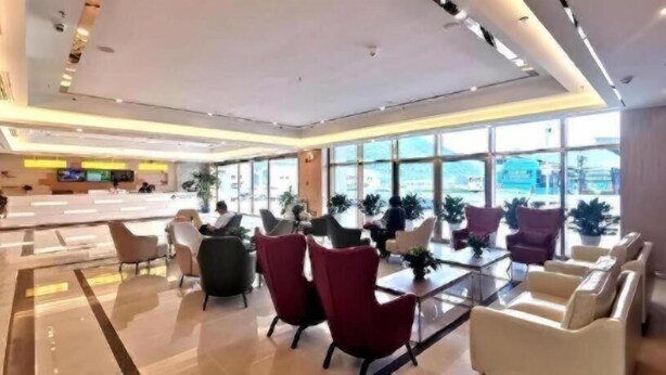 A modern hotel lobby with a reception desk, seating area, and large windows. - Greentree Inn Guiyang Wudang District High-speed Railway East Station (Guiyang)