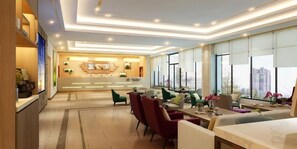 Un moderno vestíbulo de hotel con recepción, zona de estar y amplios ventanales con vistas a la ciudad.