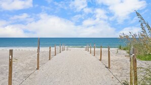 A sandy beach path leading to the ocean with wooden posts and ropes. - Heated Pool, Tiki Lounge, Steps to Beach, Games (St. Augustine)