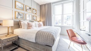 Une chambre moderne avec un grand lit, des tables de chevet, un bureau et une chaise.