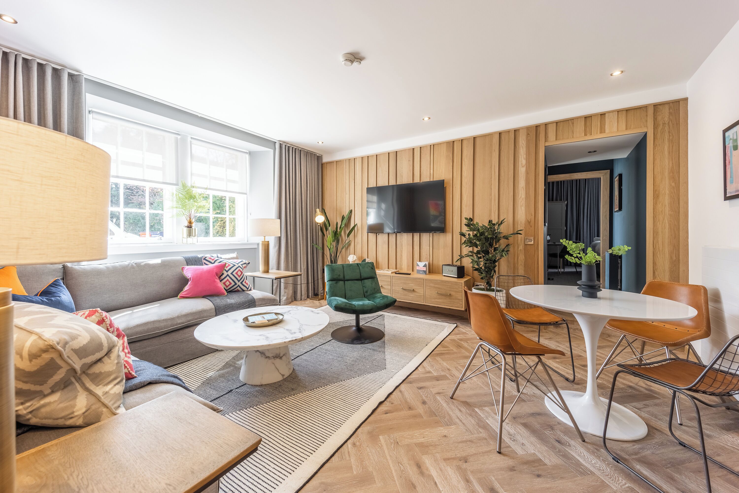 Un soggiorno moderno con un divano, un tavolino rotondo e un'area pranzo con tavolo e sedie.