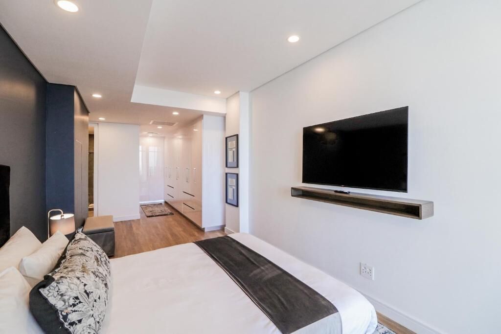 Een moderne hotelkamer met een groot bed, een wandtelevisie en een inloopkast.