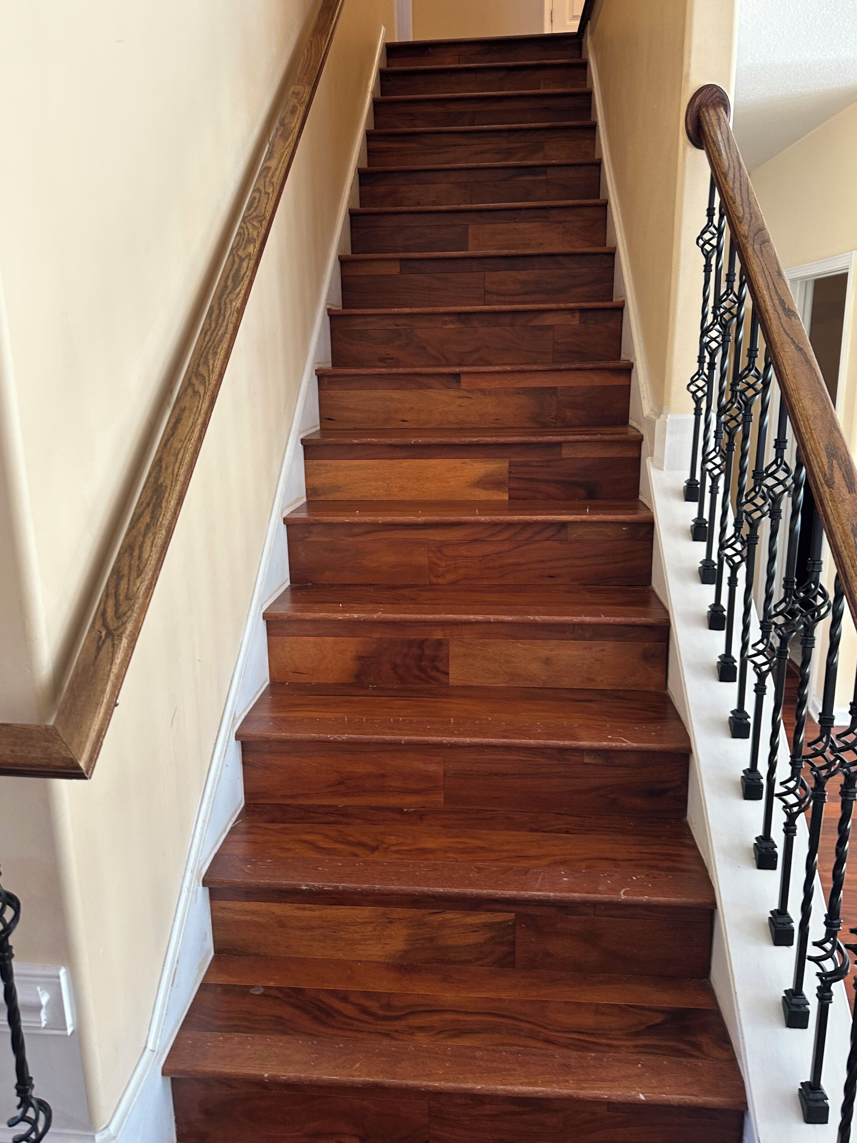 A wooden staircase with a handrail and balusters.