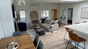 A modern living room with a sofa, coffee table, and dining area with chairs. - Beautiful 2 Bedroom Home in Santa Monica (Santa Monica)