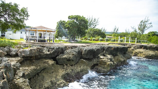 Un hotel sul lungomare con una scogliera rocciosa e vista sull'oceano.
