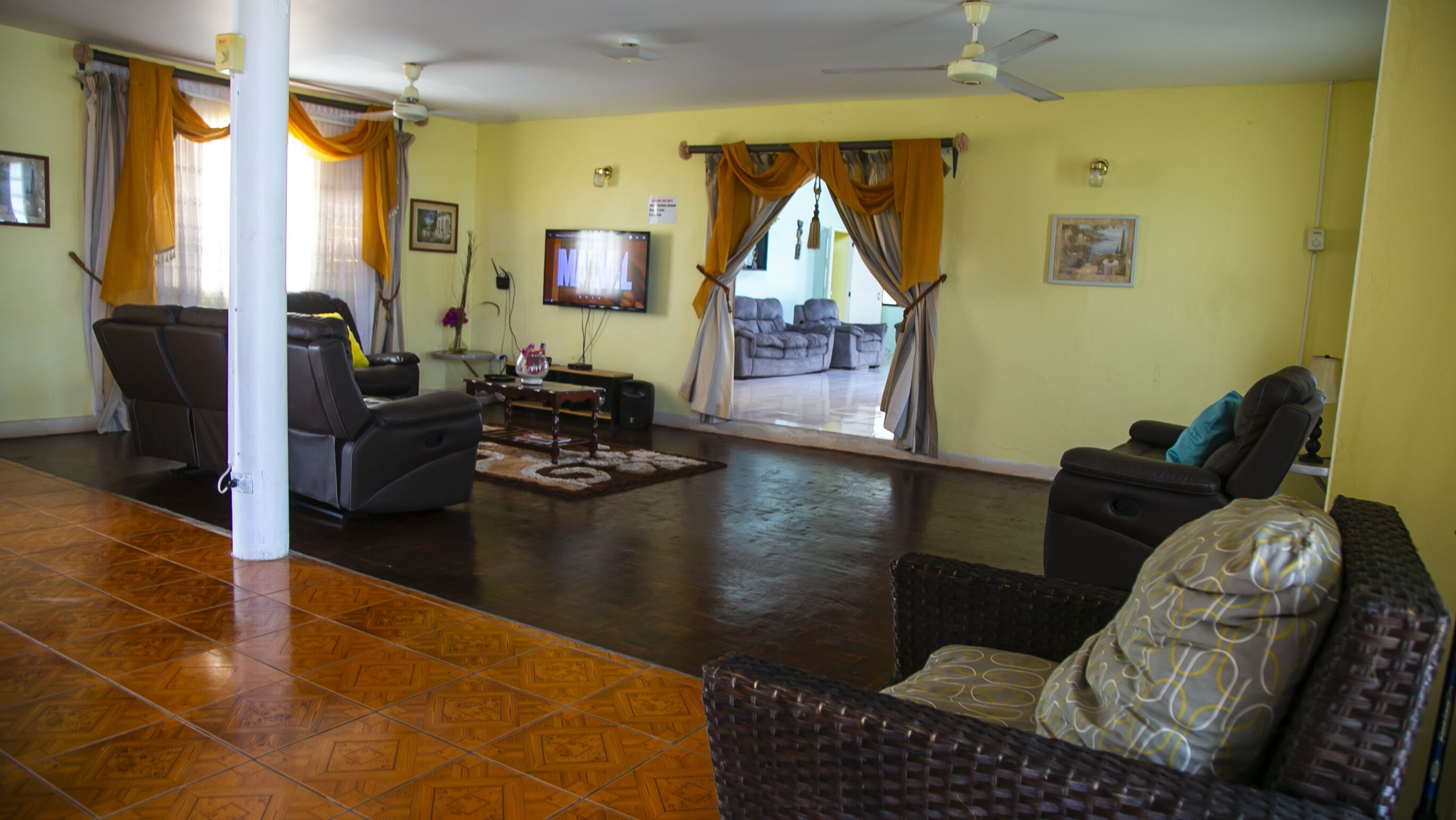 Amplia sala de estar con una televisión de pantalla plana grande, asientos cómodos y vista al exterior.