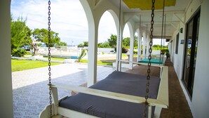 Un'area relax all'aperto con due amache e vista sul giardino e sulla piscina.