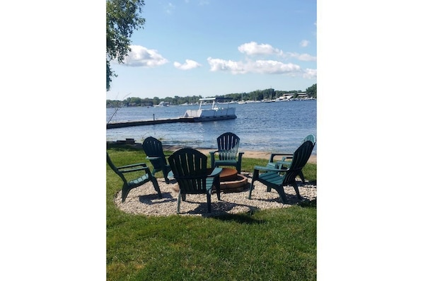 Relax by the serene lake with Adirondack chairs and a tranquil view.