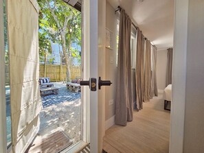 Ein Zimmer mit Blick auf einen Garten, ein Bett und eine Tür, die nach draußen führt.